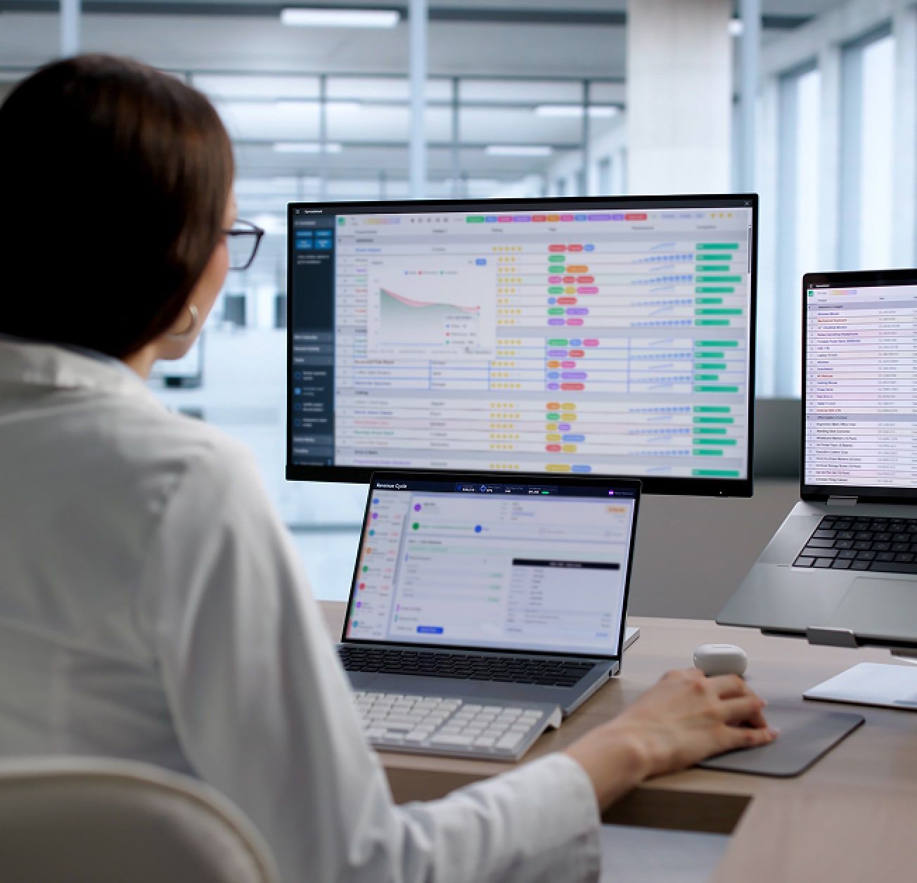 Bid analyst reviewing contract data across two monitors
