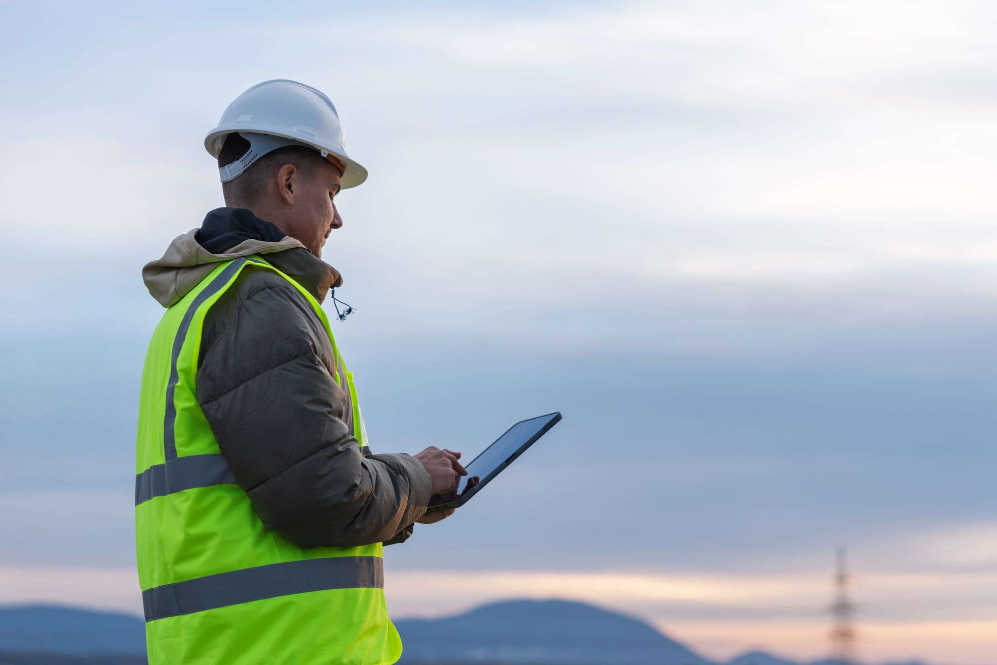 Site engineer in hi-vis using a tablet