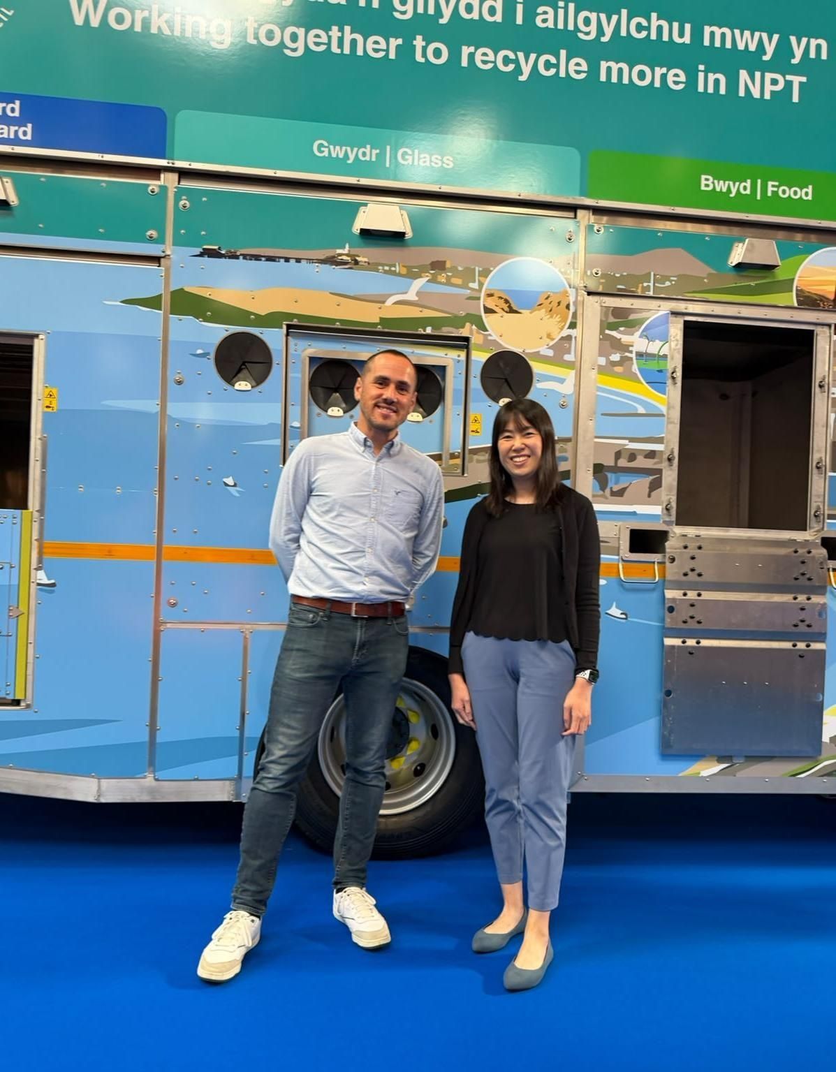 Bobby Benson and Phoebe Cheung standing in front of a recycling collection vehicle at RWM Expo